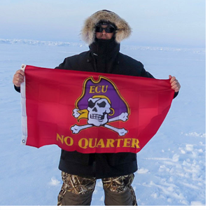 Man in polar region holding ECU flag