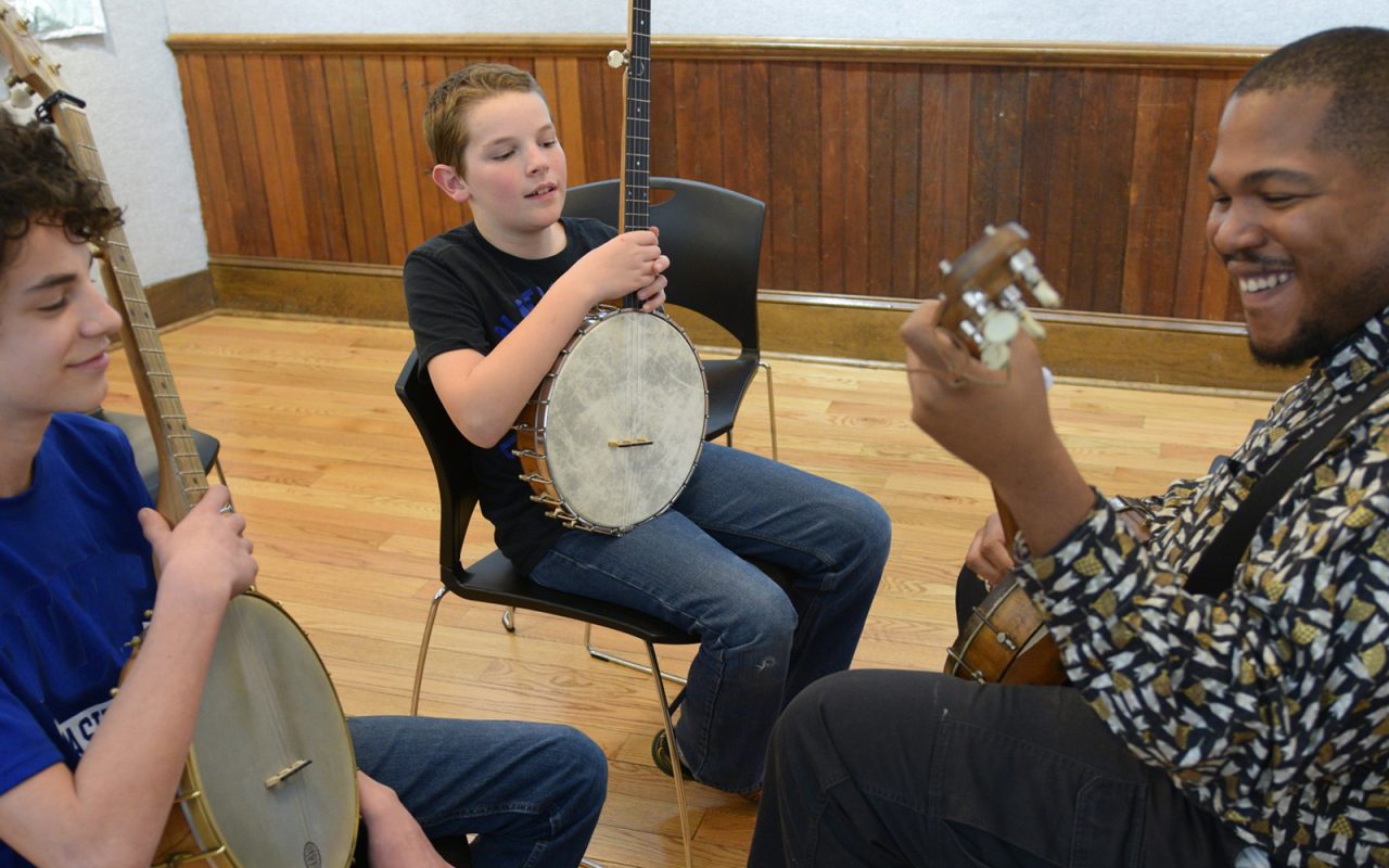 Young person holding banjo